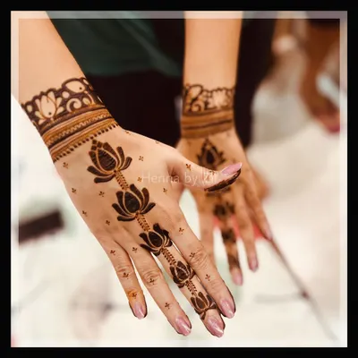 A beautiful and elegant design featuring a trail of lotus flowers running down the finger. The simple wrist cuff and scattered dots create a light and graceful look, perfect for a party.