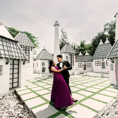 A fairytale moment comes to life at a pre-wedding set. This whimsical village backdrop provides a unique and playful setting for a romantic dance, showcasing the creative possibilities of set photography.