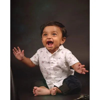 Pure, unscripted joy! This baby's expressive face is the centerpiece of this studio shot, capturing a moment of wonder during a themed "wizard" photoshoot.