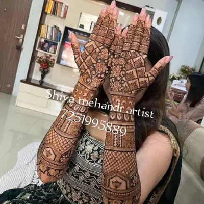 A classic full-sleeve mehendi filled with a dense checkerboard pattern and floral bands. This design offers a timeless and intricate look.