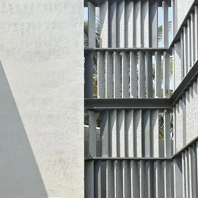 A work-in-progress shot of a west-facing facade. We designed this screen with angled stone fins to create a dynamic play of light throughout the day, while also providing shade and maintaining a connection to the street.