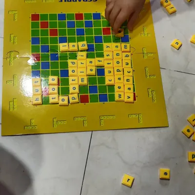 Using a Scrabble board to practice spelling and build vocabulary. We start with simple three and four-letter words, making it a fun challenge rather than a chore.