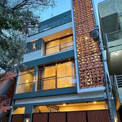 The facade of this compact Bengaluru home features a prominent terracotta jali screen. This element is not just decorative; it provides natural ventilation and privacy, making it a smart solution for urban living.