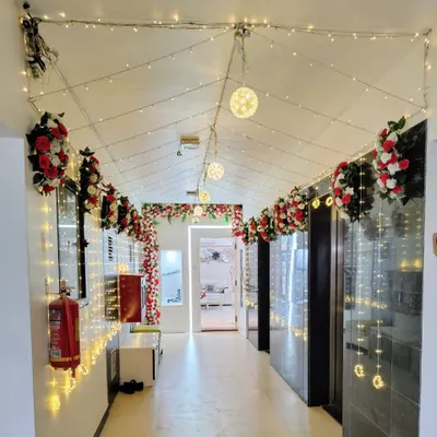 We transformed this building lobby into a magical entrance for a wedding celebration. The combination of red and white floral arrangements with cascading fairy lights creates a warm, inviting, and celebratory pathway for guests.