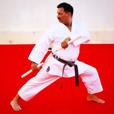 As a Renshi, my own training is lifelong. Here, I am in a traditional stance with nunchaku, a weapon that teaches fluid motion, speed, and precision.