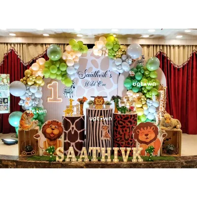 A classic "Wild One" jungle theme for Saathvik's first birthday, complete with animal cutouts and print-themed pedestals.