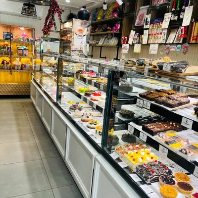 A look inside our bakery, with long display cases filled with a huge variety of freshly baked cakes, pastries, brownies, and more. There's something for everyone.