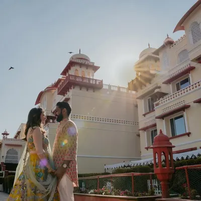 A stunning shot of a couple at the Jai Mahal Palace in Jaipur, bathed in the golden light of the sun. This image perfectly captures the 'destination wedding' dream, blending romance with royal grandeur.