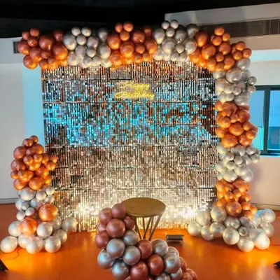 This stunning photo booth features a shimmering sequin backdrop framed by a balloon arch in metallic copper and silver. It's a glamorous addition to any anniversary or birthday party.