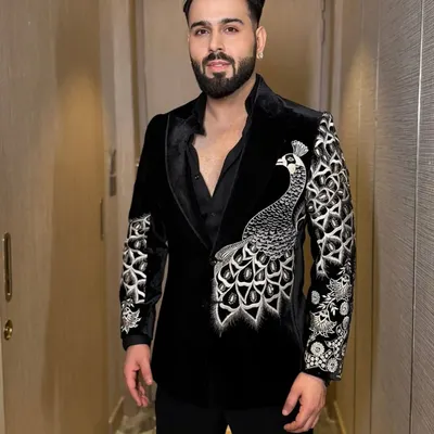 A stunning example of motif work, this black velvet tuxedo jacket features a large, beautifully detailed peacock embroidered across the front and sleeve. The silver threadwork creates a striking contrast.