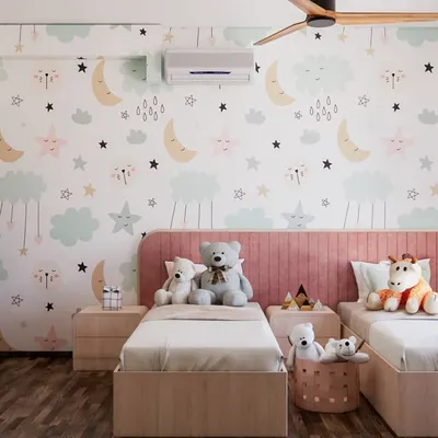A room full of whimsy and warmth. We designed this space for a sweet little girl, using a dreamy moon-and-stars wallpaper and a soft pink color palette to create a magical haven for play and rest.