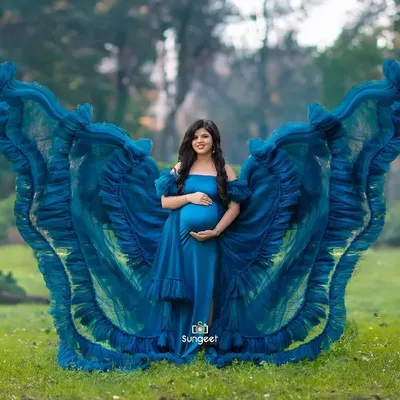 A breathtaking outdoor shot where we used fabric tossing to create a butterfly-wing effect with this vibrant blue gown. The lush greenery of the park provides a stunning contrast.