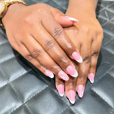 The classic French manicure is always in style. Here, I've created a clean look on almond-shaped nails with a delicate floral accent for a touch of personality.
