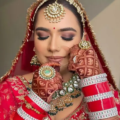My pretty bride with her eyes closed, showing off the beautiful smokey brown eyeshadow. Her look is complete with a traditional matha patti and nath.