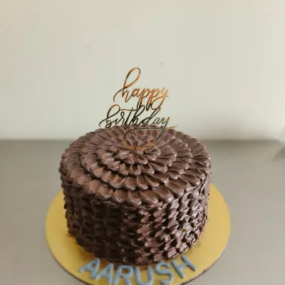 A rich chocolate truffle cake with a beautiful textured petal effect, created using a palette knife.