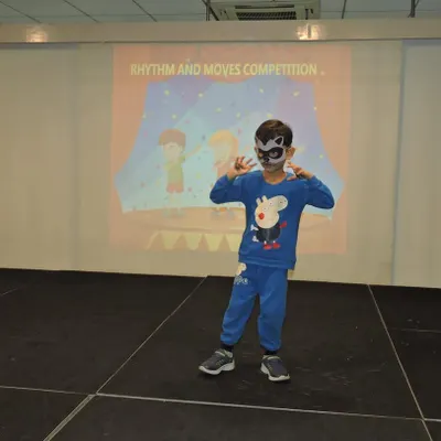 A young performer strikes a pose during our "Rhythm and Moves" competition. We encourage every child to step onto the stage, helping them build confidence and discover the joy of dance.