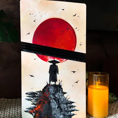 A custom PS5 console inspired by the beautiful and atmospheric game, 'Ghost of Tsushima'. The silhouette of the samurai against the red sun is such a powerful image.