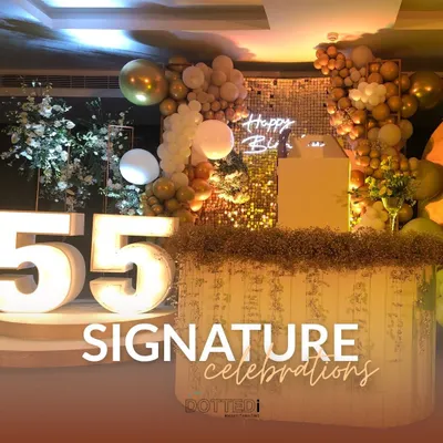 A glamorous setup for a 55th birthday, which I call my "Signature Celebrations." The decor features large marquee numbers, a gold sequin backdrop, and elegant balloon arrangements.