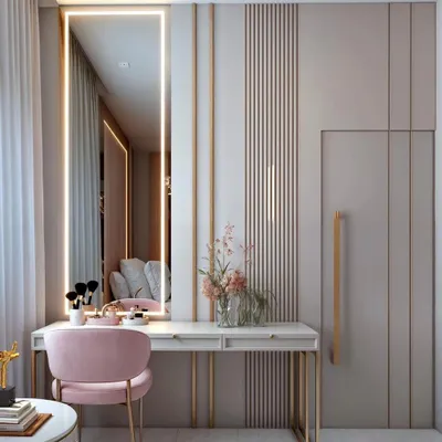 A chic and elegant vanity corner with a sleek desk, a full-length mirror with integrated lighting, and a plush pink chair. The design is seamlessly integrated with the wardrobe.