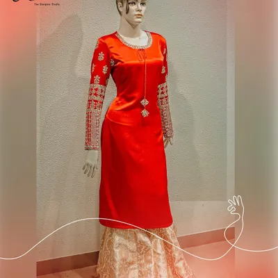 A statement in red. This long velvet kurta is paired with a classic brocade skirt, creating a regal and timeless look. The sleeves are heavily embroidered with intricate zardosi work, adding a touch of luxury.
