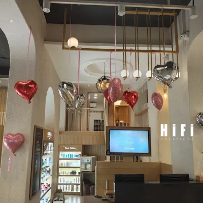 This wide shot shows how the Valentine's Day balloon decorations filled the entire two-story salon space. The hanging hearts add a festive touch without taking up any floor space, making it perfect for a busy commercial environment.