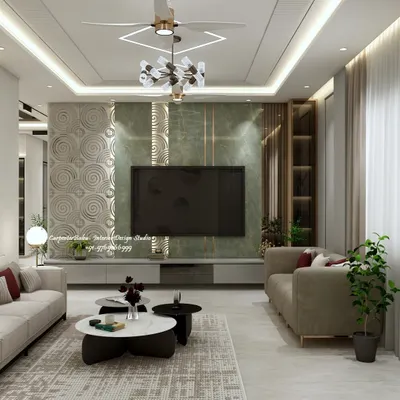 This living room features a striking TV wall that combines a rich green marble-finish panel with a 3D textured element. The design balances bold materials with the warmth of the surrounding neutral tones and cove lighting, creating a sophisticated entertainment zone.