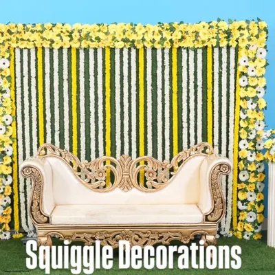 A traditional baby shower stage with a backdrop of jasmine and yellow flower garlands.