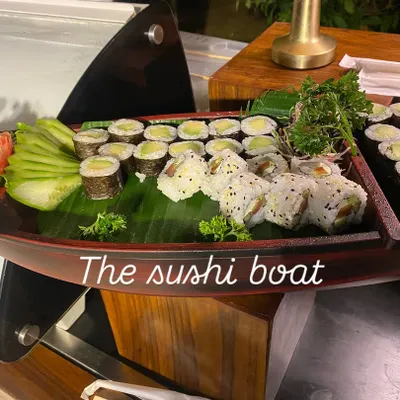 We bring authentic global flavors to your event, like this beautifully arranged sushi boat. It's a perfect example of our Pan-Asian offerings, featuring a variety of fresh sushi and maki rolls presented as a culinary centerpiece.