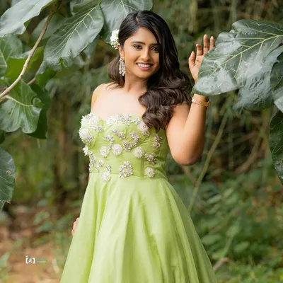 The vibrant lime green dress pops against the lush green foliage. This outdoor portrait uses natural light to create a fresh, bright, and joyful image.