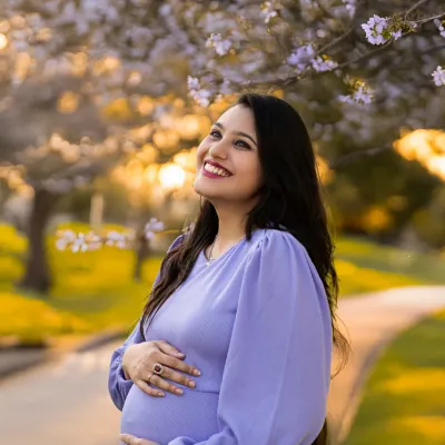 Pure joy captured during a golden hour photoshoot. The beautiful backlighting and blooming trees create a magical atmosphere for this radiant mother-to-be.