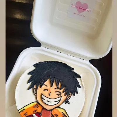 A fantastic buttercream illustration of an anime character on a bento cake. We love the challenge of capturing the energy and expression of these characters by hand.