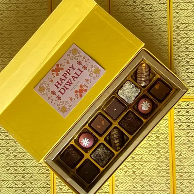 My luxury Diwali gift box, filled with an assortment of handcrafted truffles and fusion sweets. The vibrant yellow packaging and festive card make it a perfect gift for corporate clients or loved ones.