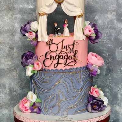 A full view of the "Just Engaged" cake, showcasing its three distinct tiers. From the lit-up proposal scene to the custom acrylic topper and detailed buttercream textures, every element is designed to tell a love story.