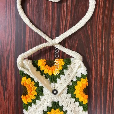 A lovely sunflower-themed granny square sling bag with a simple button closure and a heart-shaped strap, perfect for carrying your essentials.