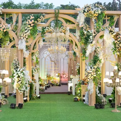 Walk through a wonderland of flowers. I designed this grand entrance with a series of wooden arches, completely covered in cascading white florals and greenery, to create a truly enchanting pathway.