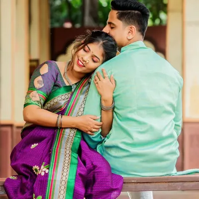 A simple, heartfelt moment on a traditional swing. Her beautiful purple saree and the rustic architectural backdrop come together to create an image that is rich in cultural elegance and emotion.