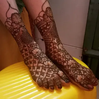 A stunning bridal leg design featuring a mix of floral and geometric patterns. The lotus and jaali (net) work create a beautiful and intricate look.
