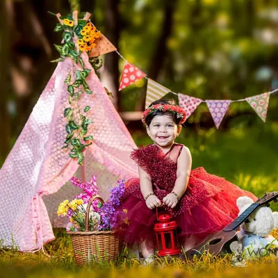 A beautiful outdoor portrait with one of my favorite props, a pink teepee. The natural light and green surroundings create a perfect setting for this little girl in her lovely red dress.