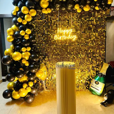A classic black and gold theme, perfect for a sophisticated party. This setup features a gold sequin backdrop, a 'Happy Birthday' neon sign, and a full balloon arch. The champagne bottle balloon adds a fun, celebratory touch.