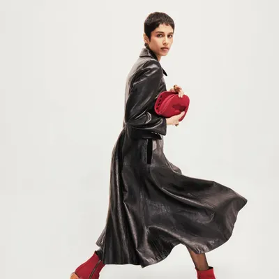 Creative direction for the footwear brand Disobedience. The model is captured mid-stride in a vintage Loewe leather look, showcasing the red boots in a dynamic, editorial style.