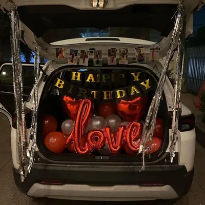 A romantic birthday surprise in the boot of a car. I used red and silver balloons, 'Happy Birthday' and 'Love' foil balloons, and a banner of personal photos to create this special moment.