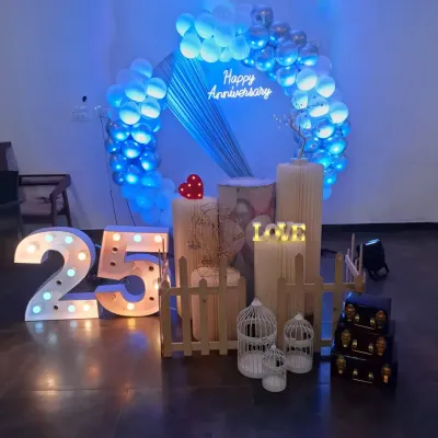 A stunning silver jubilee celebration for a 25th anniversary. I used a blue and silver color scheme, a circular backdrop with draping, and large marquee numbers to mark this incredible milestone.