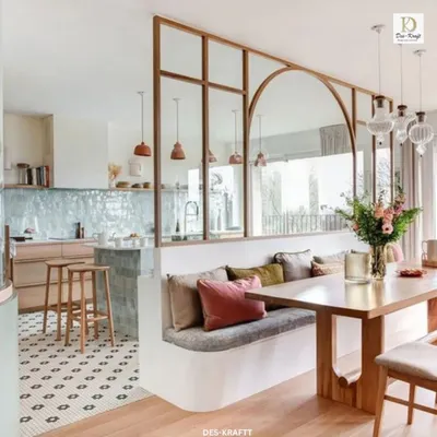 An open and airy kitchen-dining area where a glass and wood partition elegantly separates the spaces while maintaining a visual connection. The built-in bench seating maximizes space and comfort.