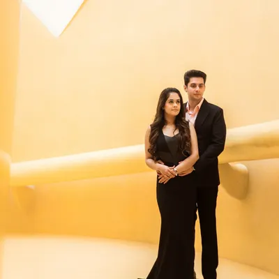 A perfect example of modern minimalism. The couple's classic black attire stands out against the bold, yellow architectural lines, creating a portrait that is both striking and sophisticated.