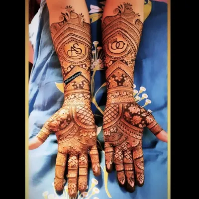 A classic engagement mehandi design featuring the couple's initials 'AS' and interlocking rings, surrounded by beautiful traditional patterns.
