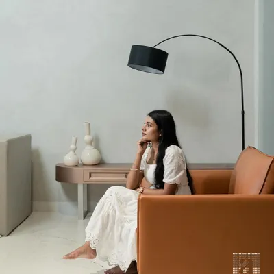 A moment of quiet contemplation in a space I designed for both elegance and comfort. The custom-made tan leather armchair provides a bold color accent against the neutral, textured walls, complemented by a modern arc floor lamp.