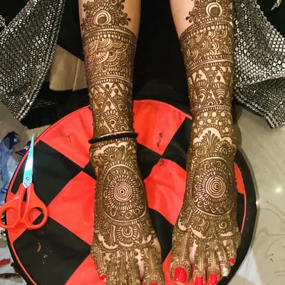 A stunning example of full bridal foot mehndi. The design covers the entire foot and ankle with intricate, traditional patterns, perfect for a bride.