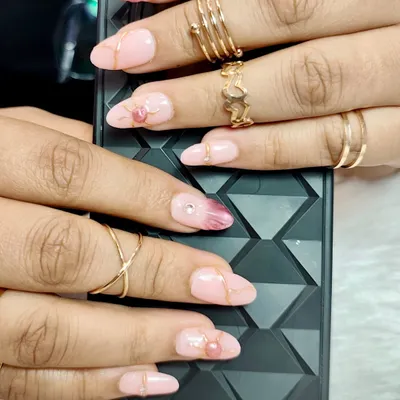 Elegance at your fingertips. This glamorous set features a soft pink base with a darker pink marble effect, gold lines, and delicate heart-shaped accents.