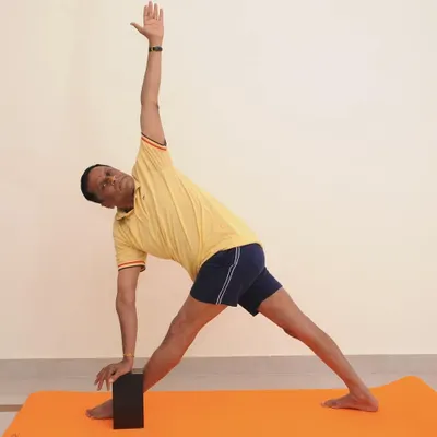 Parivrtta Trikonasana (Revolved Triangle Pose). This standing twist requires balance, hamstring flexibility, and spinal rotation. The block under the hand helps to keep the spine long.