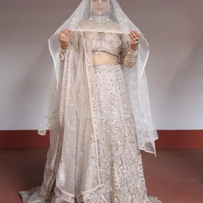 This ivory and silver lehenga is a picture of elegance. The sheer veil adds a touch of drama, making it perfect for a bridesmaid or for an engagement shoot.